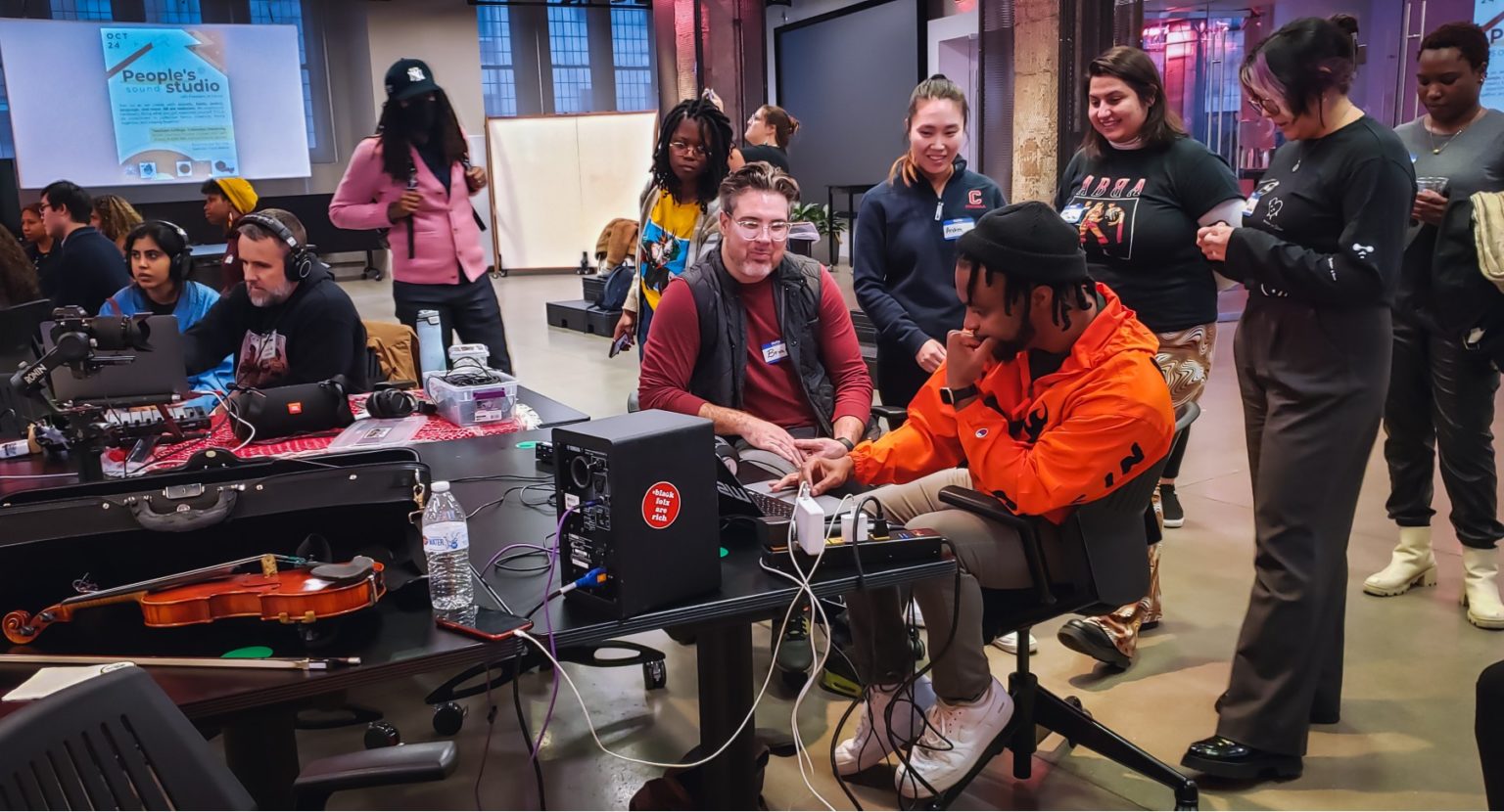 Students wearing headphones working on laptops to create beats, sounds, poetry, and more.